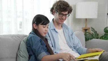 Beyaz bir baba ve tatlı bir kız kanepede otururken masal kitabı okuyorlar. Mutlu bir baba, sevimli bir Amerikan çocuğuna, birlikte zaman geçirirken hayal gücünün gelişmesi için hikaye anlatıyor. Pedagoji.