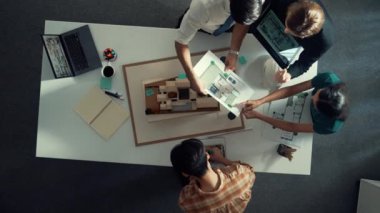 Yöneticinin ev modelini göstermesi ve bina tasarımını açıklaması. Tablet ev planı sergilenirken iç yapı hakkında beyin fırtınası yapan mimar mühendisinin hava görüntüsü. Hizalama.