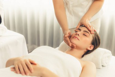 Kafkasyalı kadın stres önleyici kafa masajından ve lüks tatil beldesi ya da otel spa salonundaki modern ışık ortamında yüz güzelliği eğlencelerini şımartmaktan hoşlanıyor. Sessiz.