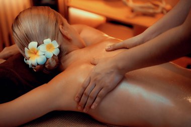 Beyaz kadın müşteri stres önleyici spa masajının keyfini çıkarıyor ve lüks otel ya da otelde sıcak mum ışığında güzellik teniyle eğleniyor. Sessiz.