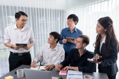 Bir grup farklı ofis çalışanı şirket ofis odasında stratejik iş pazarlama planlamasında birlikte çalışıyor. İş yeri konseptinde pozitif takım çalışması. Tedbirli