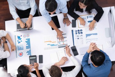 Üst görünüm proje yöneticisi proje yönetimi yazılımı kullanarak ekip ile iletişim kurar ve işbirliği yapar, proje görevinin ilerlemesini izler ve toplantı masasında program planı yapar. Tedbirli
