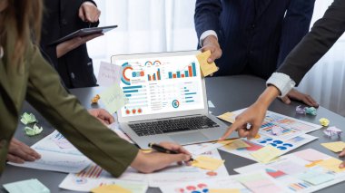 Analizci ekibi yaratıcı ve analitik beyin fırtınası fikri için bilgisayar ekranında BI veri paneli olan yapışkan bir not kullanıyor. Pazarlama stratejisi için finansal veri görselleştirme teknolojisini analiz et. Dahi.