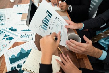 Ofis masasındaki finansal veri raporlarını analiz eden çeşitli bir grup iş analisti. Stratejik pazarlama planlaması için iş istihbarat analizine göre grafikler ve grafikler.