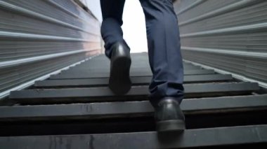 Merdivenlerden çıkan başarılı iş adamının bacağına yakın plan. Müdürün iş yerini değiştirmesi, yeni bir şey keşfetmesi, gelişmesi, terfi etmesi ya da gün ışığına çıkması. Yükseliyor. Bacağa odaklan. Sevinçli..