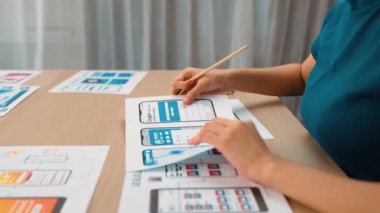 Mobil uygulama için kullanıcı arayüzü prototipi ya da masadaki program modeliyle birlikte web sitesi planlaması yapan bir şirket çalışanı. UX UI tasarımcısı kullanıcı dostu arayüz planını dikkate alır. Sinerjik
