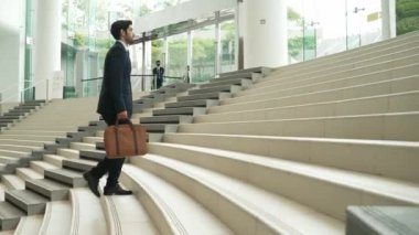 Profesyonel iş adamı merdivenlerden çıkıyor. Başarılı bir adam merdivenleri çıkarken yeni bir şey keşfediyor. Seyahat etmeyi, terfi etmeyi, yeni bir iş bulmayı, yeteneğini arttırmayı temsil etti. Sevinçli..