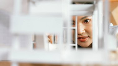 İnşaat çalışmalarını incelerken mimar mühendisin portresi ev modelini inceliyor. Proje yöneticisi ev modelini kontrol ediyor. İş tasarımı konsepti. Yüzüne odaklan. Yönlendirici.