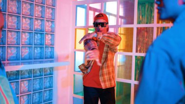 Kafkas dansçısı dans ederken çeşitli arkadaşları gece kulübünde neon ışıkta ayak seslerine bakıyor. Çoklu etnik kökenli hipsterin serbest stil müziğe geçişi ve mutlu bir adamın kameraya bakışıyla. Mutluluk.