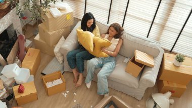 Lezbiyen aşığın taşınma gününde oturma odasında kanepede otururken yastık savaşı yapması. Oda arkadaşı odada yastık tutarken birlikte vakit geçirir. Kutu etrafa saçılmış halde. Myrmidon.