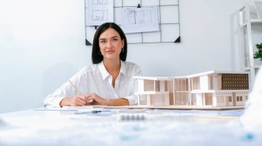 Profesyonel mühendis ekibinin yakın plan görüntüsü modern ofisin inşaatı hakkında tartışılıyor. Erkek mühendis haritayı masaya koyarken güzel mimar not alıyor. Tertemiz..