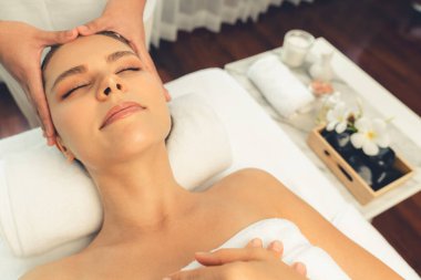 Kafkasyalı kadın stres önleyici kafa masajından ve lüks tatil beldesi ya da otel spa salonundaki modern ışık ortamında yüz güzelliği eğlencelerini şımartmaktan hoşlanıyor. Sessiz.