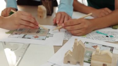 Mimari döküman, ölçüm araçları ve ahşap blokların modern ofiste etrafa saçıldığı masa üzerine planlar yapma konusunda akıllı mimar ve güvenlik mühendisi tartışması. - Yakın çekim. Tanımlama.