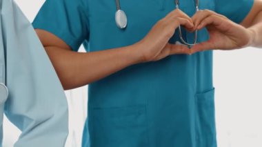 Profesyonel sağlık personeli kuyrukta bekleyip, birlikte el kaldırarak sağlık hizmetleri ve hastanedeki doktor liderliğini sembolize ediyorlar. Takım çalışması başarılı tedaviye yol açar. Düşük hareket. Katı.