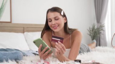 Genç bir kadın kredi kartıyla ödemek için internet üzerinden ödeme uygulaması ve dijital cüzdan kullanıyor. Mobil internet üzerinden alışveriş ve modern alımlar. Düzenle