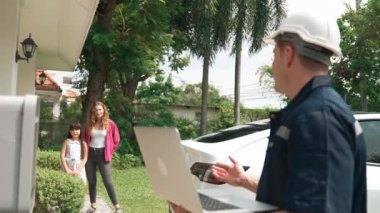 Evde EV şarj istasyonu kurulumu üzerinde çalışan nitelikli teknisyen, EV için dizüstü bilgisayarla şarj sisteminde sorun çıkarma ve yapılandırma ayarları yapıyor. Titiz