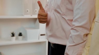 Panoramik video mutlu Asyalı şirket çalışanı renkli günlük kıyafet giyer yan yana durur yaratıcı takım çalışmasını, iş istihdamını, HR ajansını sembolize eden başparmağını kaldırır. Sinerjik