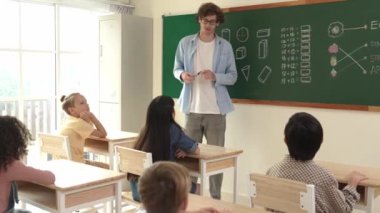 Öğrenciye bakarken, sınıfta matematik teorisi hakkında konuşan ve açıklayan beyaz bir öğretmen. Tahtanın önünde durup tahtaya işaret eden yetenekli bir eğitmen. Pedagoji.