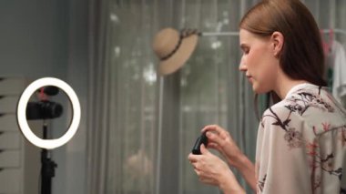 Kadın nüfuzlu kişi sosyal medya ya da blog için canlı yayın yapan video klip eleştirmeni Cilt Bakımı 'nı çekiyor. Kozmetik stüdyosu ışıklandırmalı mutlu genç kız çevrimiçi pazarlama oturumu yayını için..