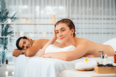 Lüks spa salonlarında sıcak mum ışığında cilt bakımı gören mutlu çift müşterisi. Sağlık kaplıcasında güzellik tedavisiyle tuz temizliği. Sessiz.