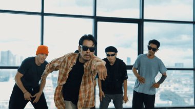 Çok kültürlü hipster grubu kameraya bakarken gökyüzü avcısıyla ya da şehir manzaralı bir binada break dans yapıyorlar. Sokak dansçısı ekibi dansçı performansına bakıyor. Açık hava sporu 2024 hiphop..