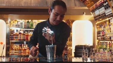 Asyalı barmenin karışık kokteyl likörünü likör karışımına katması, özel reklamı yaratıcı, canlandırıcı, bar lüksünde canlandırıcı bir vitrin haline getiriyor. Vinosity.