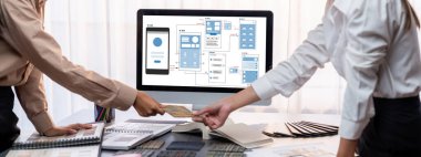 Masadaki bir grup iç mimar takımı dizüstü bilgisayarında mimari yazılım bulunan çeşitli ruh hali tahtası örneklerini seçiyor. Modern yenileme ve iç malzeme seçimi konsepti. İçgörü