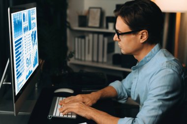 Akıllı iş adamı iş paragrafı dinamik pazarlama analizi planını analiz ediyor. Kağıt kağıtları ve bilgisayar monitörü raporlarını gece evdeki belge verileriyle karşılaştırmak için hazırlıyor. Bireysel.