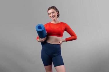 Vücut uzunluğunun tamamı atletik ve sportif genç bir kadının izole edilmiş arka planda egzersiz duruşu ile geçiyor. Sağlıklı aktif ve vücut bakımı yaşam tarzı.