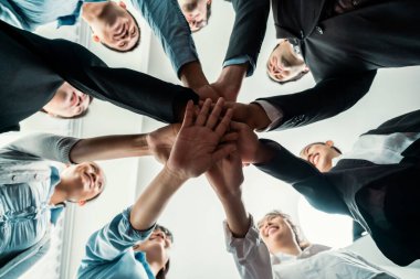 Çok ırklı iş adamları toplantı odasında iş birliği ya da şirket çalışanları için takım oluşturma amacıyla bir araya toplanıyorlar. Yakından, aşağıdan. Habiliment