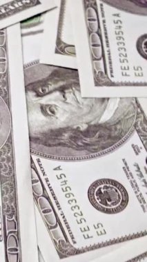 Ofis masasında 100 dolarlık kağıt para yığını. Maliye ve para ödemesi kavramı.