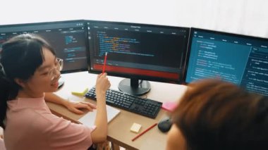 Yavaş çekim arkası yazılım geliştirici mühendisi bilgisayar programlama için birlikte çalışarak hata ayıklama kodunu çözüyor, ofiste monitörde karmaşık algoritmaları çözüyor. Filizlenen