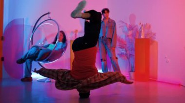 Arkadaş neon ışıklı dans stüdyosuyla performansı izlerken mutlu hipster kafa sallıyor. Zeki insanlar kameraya poz verirken profesyonel beyaz adam müziğe yöneliyor. Mutluluk.