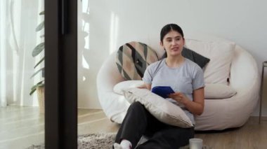 Kanepede oturan orta yaşlı bir kadın, sosyal ve teknolojik mesleki gelişmeler hakkında ders kitabı okur ya da zeki bir anne olmak için çocuk yetiştirir. Hayat boyu öğrenme konsepti. Uyumsuzluk.