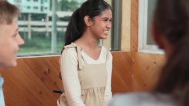 Genç öğrenci toplantıda veya grup tartışmasında diğer öğrencileri dinlerken gülümsüyor. Tecrübelerinden ve karışık ırktan arkadaşlarıyla paylaştığından bahseden sevimli bir genç. Yaratıcı eğitim. Öğretim