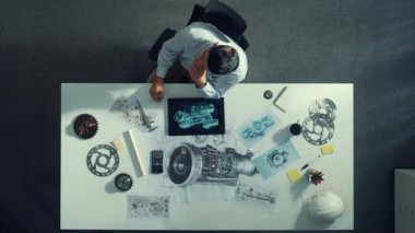 İş arkadaşı toplantıda yürürken akıllı müdürün oturduğu en tepeden aşağıya hava görüntüsü. Meslektaşı soru sorarken türbin motoru ya da elektronik jeneratöre bakan profesyonel bir mühendis. Hizalama.