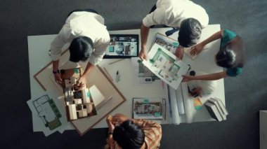 Akıllı mimar mühendisinin planlarını mimari ekipmanlar kullanarak ölçerken tasarımcılar toplantı odasında bina tasarımı ya da ev inşaatı hakkında konuşuyorlar. Hizalama.