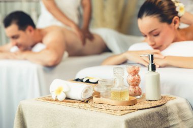 Aromaterapi masajı gündüz atmosferinde ya da spa salonunda bulanık bir kadına odak dekor ve spa aksesuarları kurarak tatil köyünde ya da otel arka planında keyifli aroma spa masajı yapan bir masaj. Sessiz.