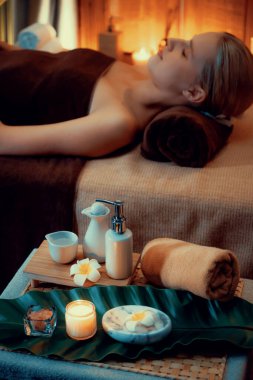 Aromaterapi masajı ambiyansı ya da spa salonu kompozisyon düzeneği bulanık kadınlara odaklı dekor mumları ve spa aksesuarları ile tatil köyü veya otel arka planında keyifli aroma spa masajı yapan. Sessiz.