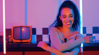 Stüdyoda mor ışıkla sokak dansı yapan İspanyol sokak dansçılarına yakın çekim. Profesyonel sanatçı şık kumaşla enerjik bir hareket sergiler. Çılgın, komik. Yarı vücut. Mutluluk.