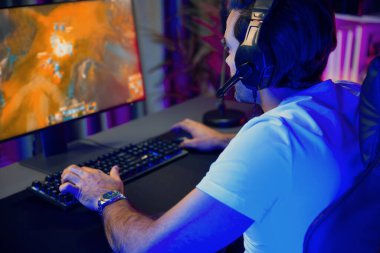 Moba çevrimiçi oyununa odaklanan akıllı akım oyunculu kulaklıklar takarak bilgisayar ekranında mupti ya da neon dijital siber ışık odasındaki savaş alanında yetenekli bir takım ile birlikte. Tahmin et..