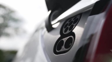 EV şarj prizi kapağı elektrikli arabaya bağlanıyor, EV araba aküsünü temiz çevre için sıfır CO2 emisyonu ile alternatif ve sürdürülebilir enerjiyle şarj ediyor. Titiz