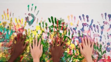 Değişik öğrenci elleri rengarenk duvarlara yerleştirilirken yer değiştiriyorlar. El ya da karışık ırktan çocuklar el izlerini ve hareketlerini boyarlar. Geçmişi. Yaratıcı aktivite. Öğretim