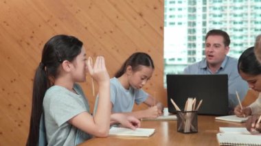 Akıllı öğrenci çalışmalarını kontrol ettiği için mutlu öğretmen diye el kaldırdı. Liseli kız not defterine bakan yetenekli bir öğretmen ve sınıfta onu cesaretlendiren bir başparmak gösteriyor. Yaratıcı. Öğretim