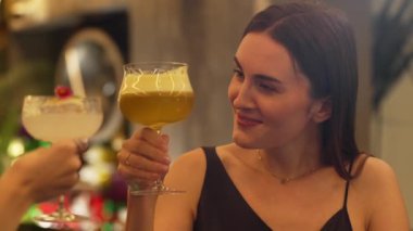 Güzel bir kadın, elinde bir bardak hindistan cevizli, köpüksüz içecek olan bir arkadaşıyla karışık çarkıfelek meyveli kokteyli hazırlıyor. Gece kulübü tezgahı partisinde canlı bir sohbete girişiyor. Vinosity.