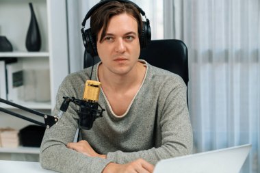 Sunucu kanalı, gülümseyen akıllı yayıncı kaydı, senaryosu ve akıllı telefonuyla sosyal medyada sohbet programı, kulaklık takarak modern ev stüdyosundaki video flamalarını kaydediyor. Bireysel.