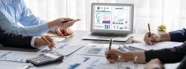 İş zekası ve veri analizi kavramı. Analizci ekibi laptop ekranında finansal veri analizi üzerinde çalışıyor. Etkili iş stratejik planlama için pazarlama göstergesi olarak. İçgörü