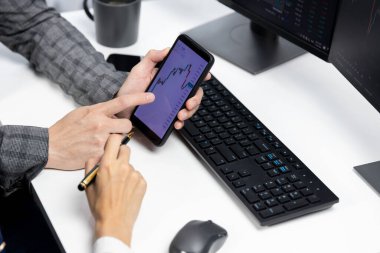 İşadamı olarak kalemle işaretlenmiş, kadın yatırımcının internet sitesi program uygulamasının akıllı telefonuyla kontrol ediliyor. İç işlerindeki dinamik borsa ile kontrol ediliyor. İnfobahn.