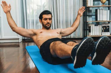 Atletik ve sporcu adam, evde vücut egzersizi yaparken spor ve spor yaşam tarzına uyum sağlamak için spor minderinde çatırdıyor. Gaiety ev egzersizi antrenman konsepti.