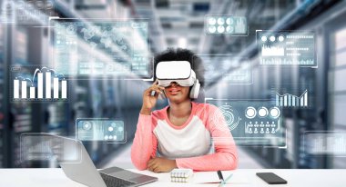 Masada kitap ve dizüstü bilgisayarla ödev yaparken metaevreleri birbirine bağlayan dizüstü bilgisayar ve artırılmış gözlük kullanan bir kız. Öğrenci holograma bakıyor ve yapay zekayı kullanıyor. Yaratıcılık.